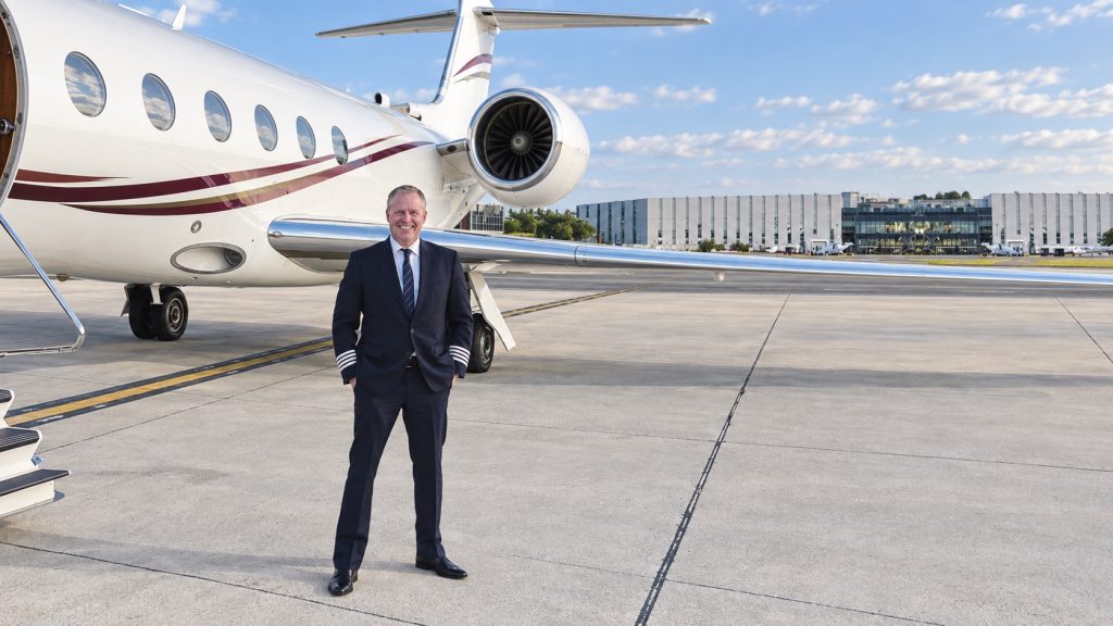 FAA pilot examiner Jason E. Jacobs standing beside a business jet